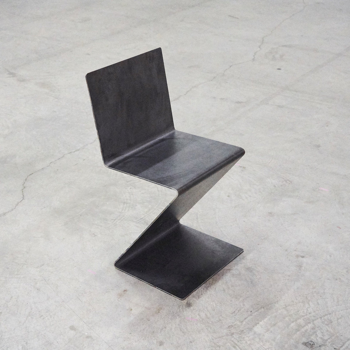 Freischwinger aus rohem Flachstahl und Rückenlehne, gefertigt aus einem Stück Flachstahl ohne Schweißnaht auf Betonboden